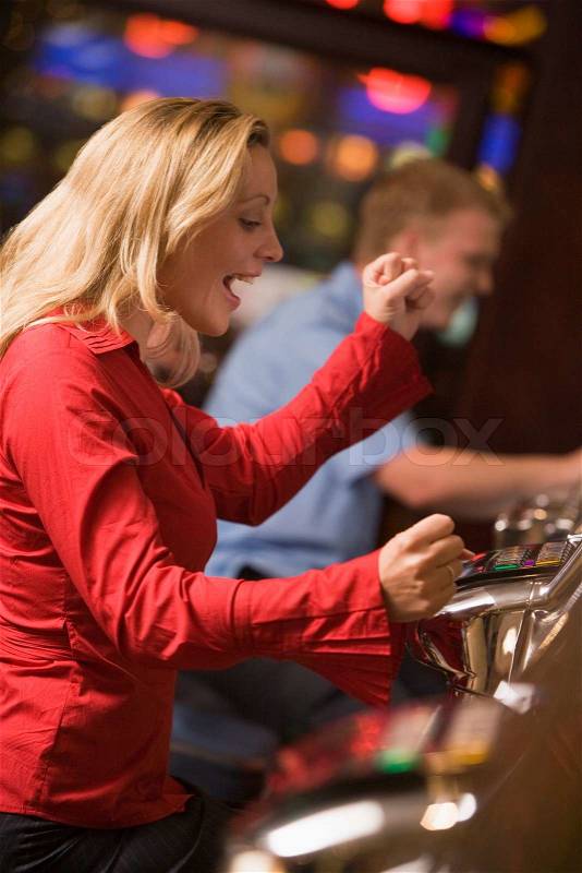 Stock image of 'Woman celebrating win on slot machine at casino&#39