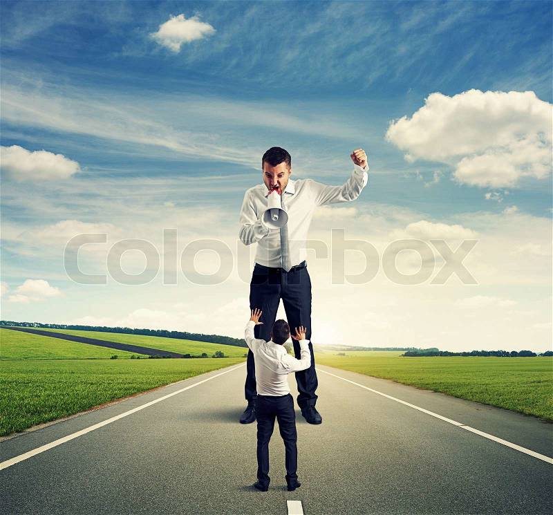 Fight between angry man and small scared man on the road, stock photo