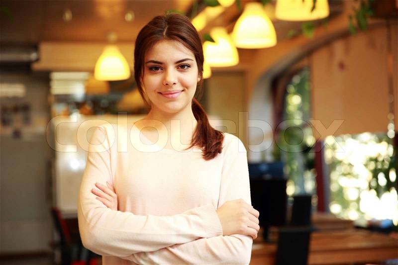 Portrait of a young smiling woman with arms folded, stock photo