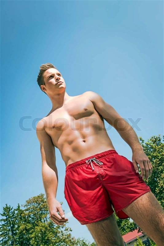 Picture of a attractive young man in swimming shorts, stock photo