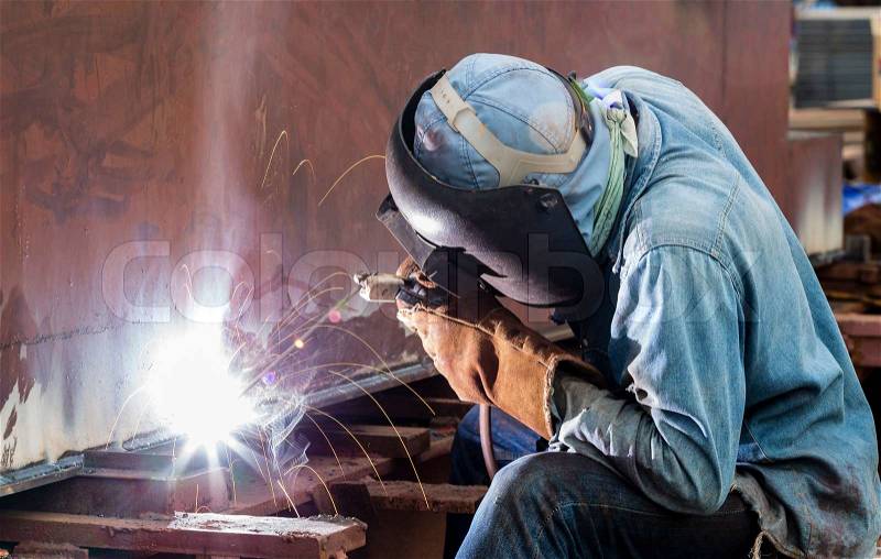 Worker with protective mask welding metal , stock photo