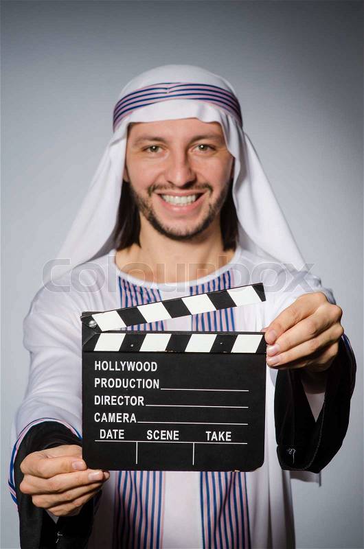 Arab businessman with movie board, stock photo