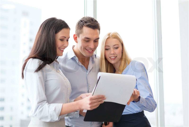 Business and office concept - business team looking at clipboard, stock photo