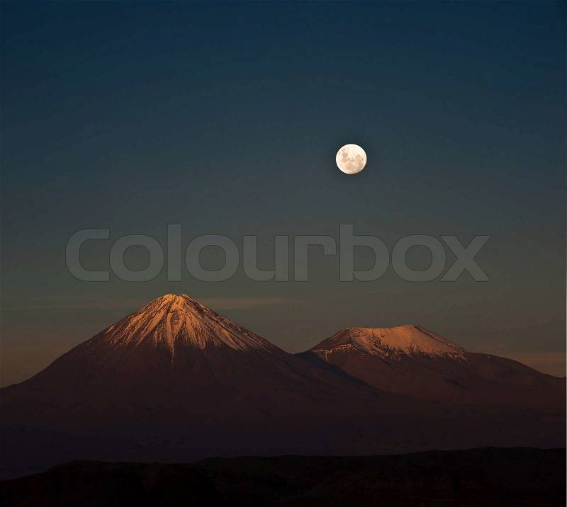 Full-moon in the Moon Valley. Volcanoes Licancabur and Juriques, west of San Pedro de Atacama, Chile in the Cordillera de la Sal, in the Atacama desert of Chile, stock photo