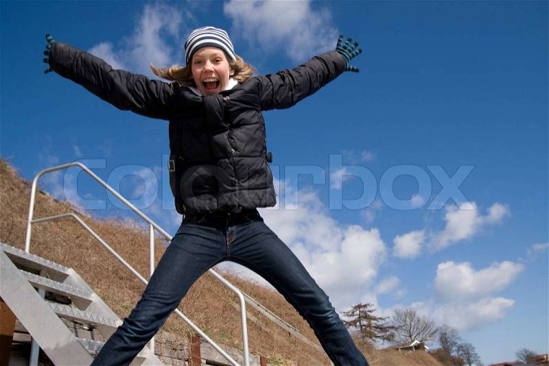 Teenage girl jumping for joy, stock photo
