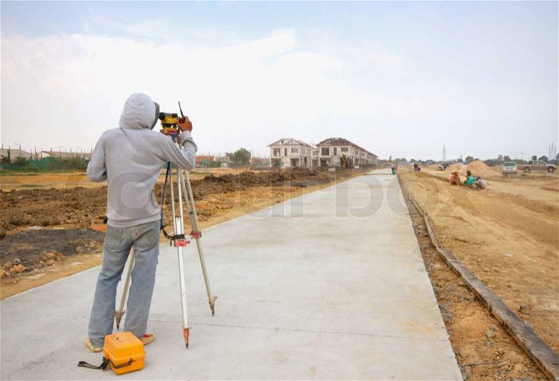 Surveyor engineer making measure on the road, stock photo