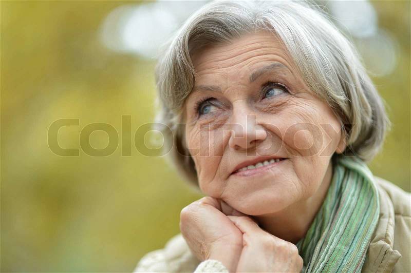 Cute elderly woman walking in the park, stock photo