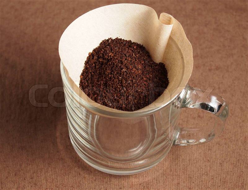 Preparing Grinded coffee crop on paper filter, stock photo