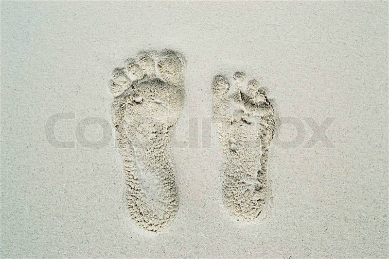 Male & female footsteps on a beach sand, stock photo