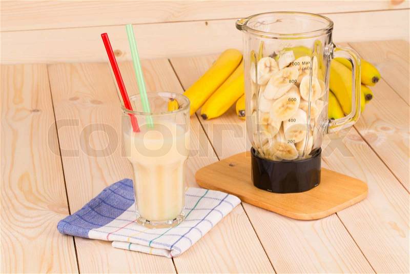 Banana juice and blender full of sliced fruits, stock photo