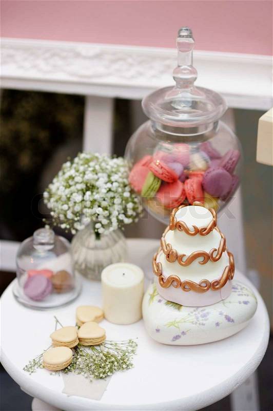 Elegant sweet table with little cake and macaroon on dinner or event party, stock photo