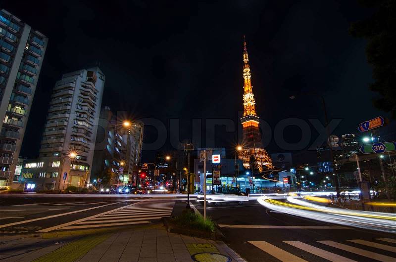 TOKYO, JAPAN - NOVEMBER 28: View of busy street at night with Tokyo Tower in the distance in Tokyo, Japan on November 28, 2013, stock photo