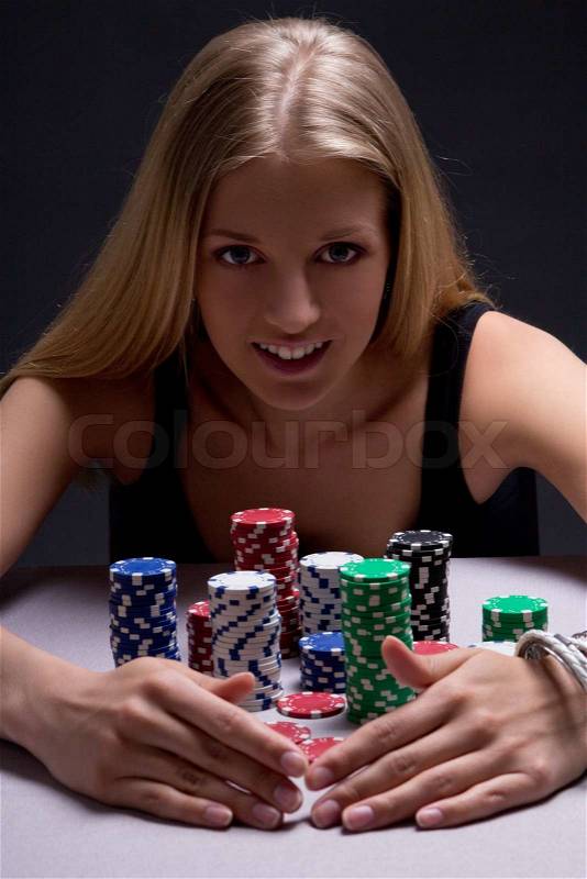 Young beautiful blond woman with poker chips in casino, stock photo