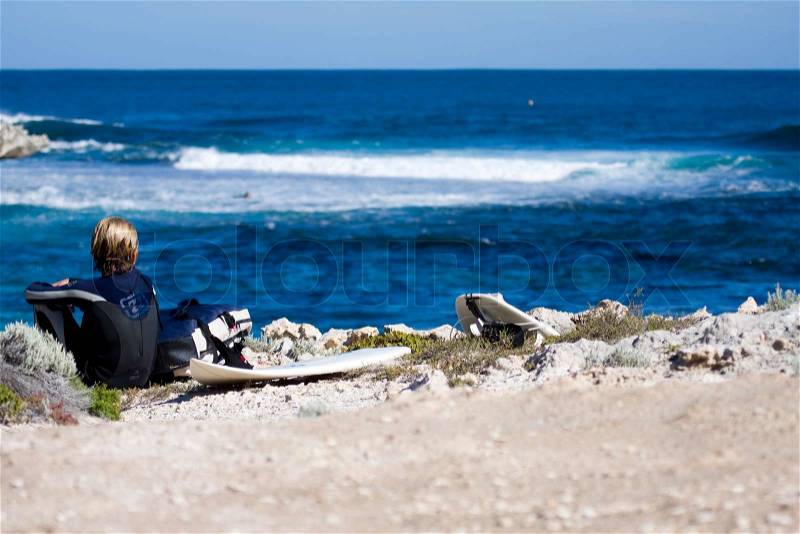 A male surfer looking at the sea waves, stock photo