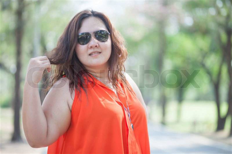 Close up of happy fatty asian woman outdoor in a park, stock photo