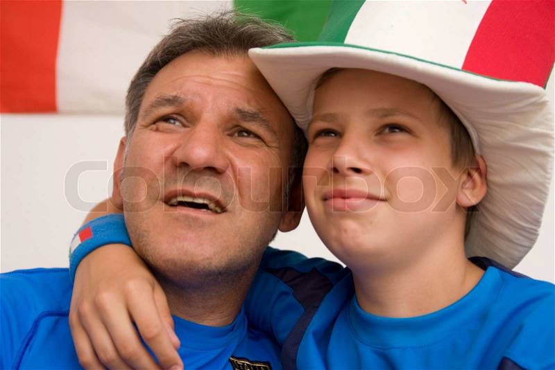 Faces of excited father and son watching Italian football, stock photo