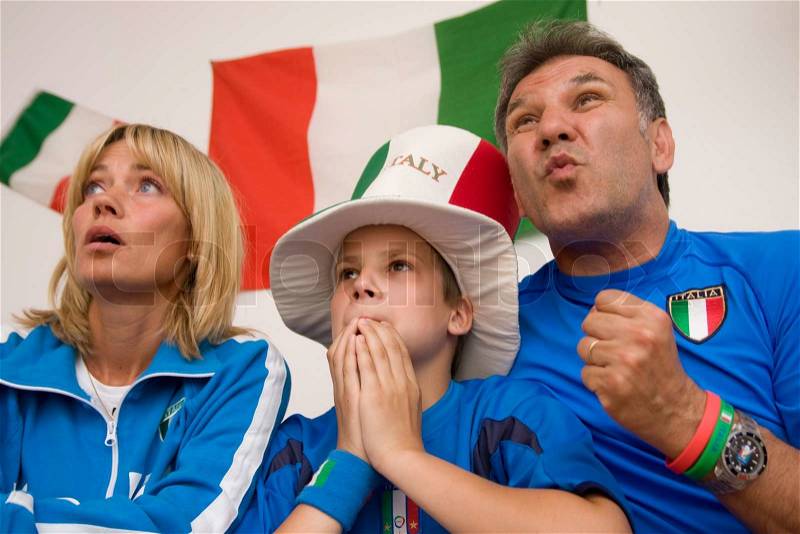 Excited faces of a family watching Italian football, stock photo