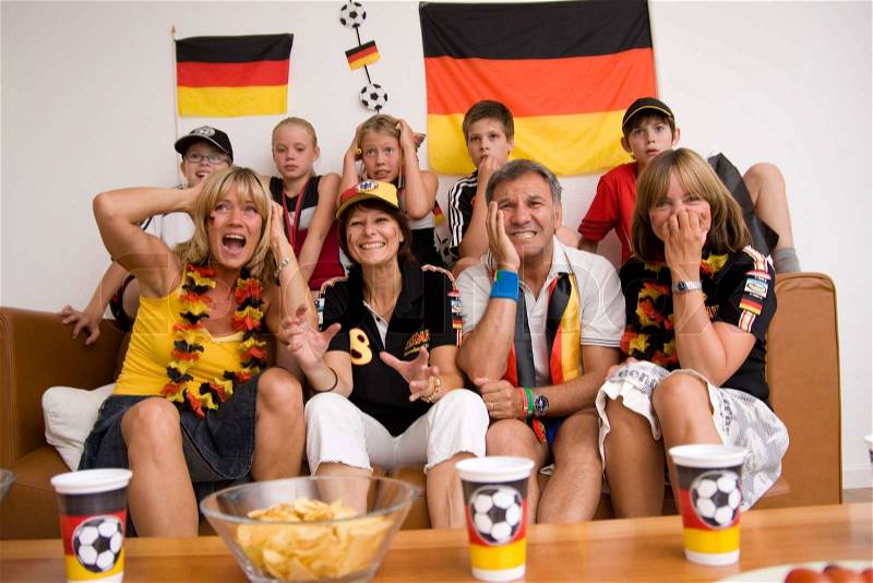 Excited German fans watching football championship, stock photo