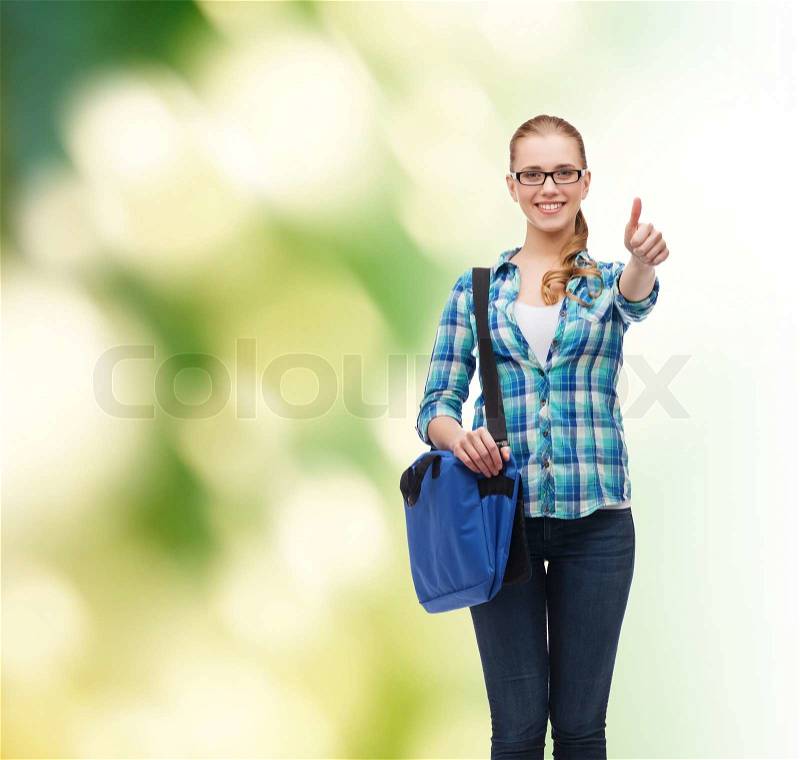 Education and people concept - smiling female student in eyeglasses with laptop bag showing thumbs up over green background, stock photo