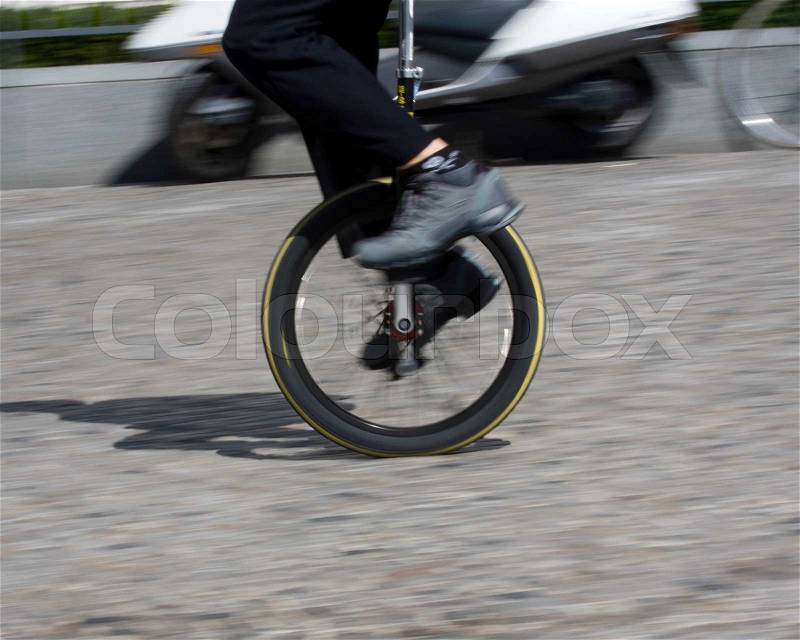 Cropped image of man on a unicycle, stock photo