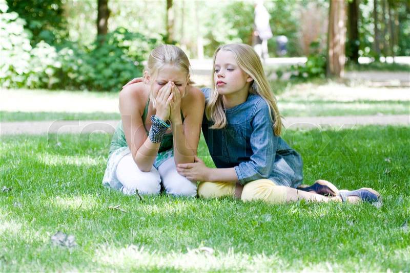 A crying teenage girl being comforted by a friend, stock photo