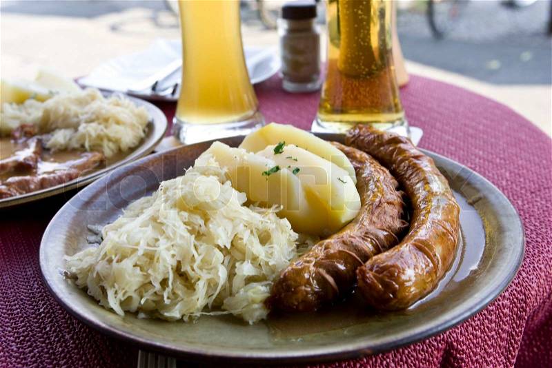 German sausages, potatoes and sauerkrat on a plate, stock photo