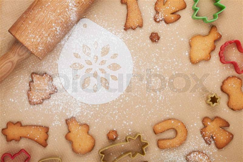 Rolling pin and gingerbread cookies on cooking paper, stock photo