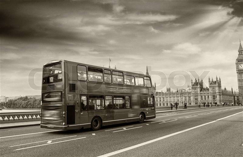 Westminster Bridge, London. Red Double Decker Bus speeding up at dusk in front of Big Ben, stock photo