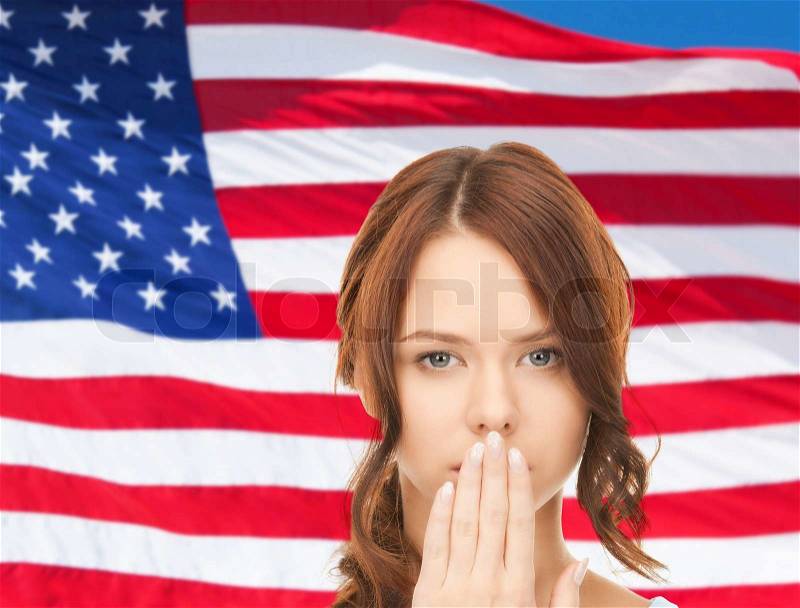 Usa politics, conspiracy and secrecy concept - woman with hand over mouth on american flag background, stock photo