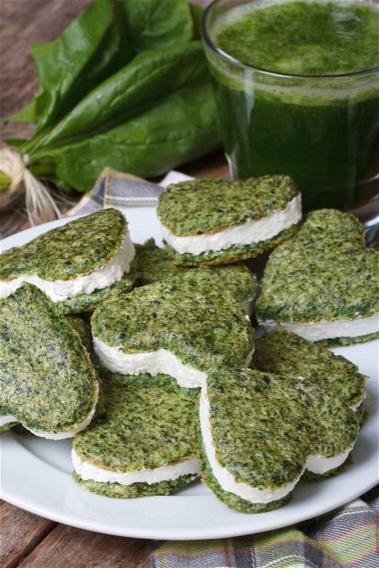 Green cookie hearts, fresh spinach and vtaminny drink on the old table closeup vertical , stock photo