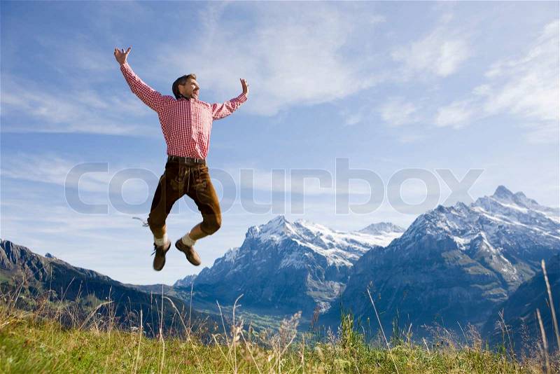 A man in Switzerland jumping for joy, stock photo