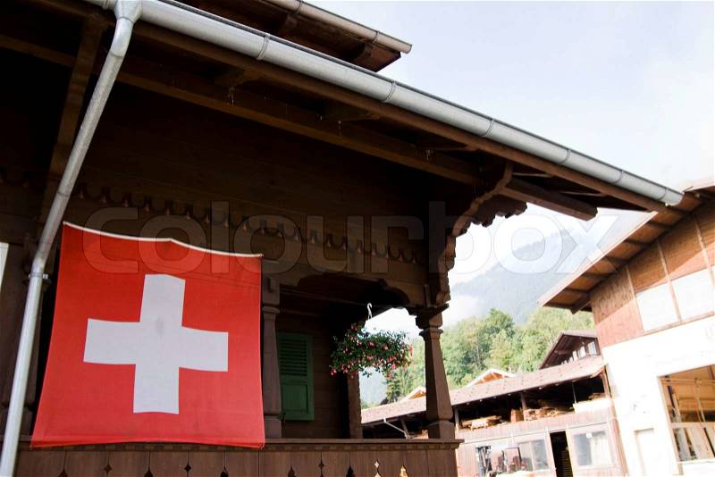 Swiss flag on a traditional swiss house, stock photo