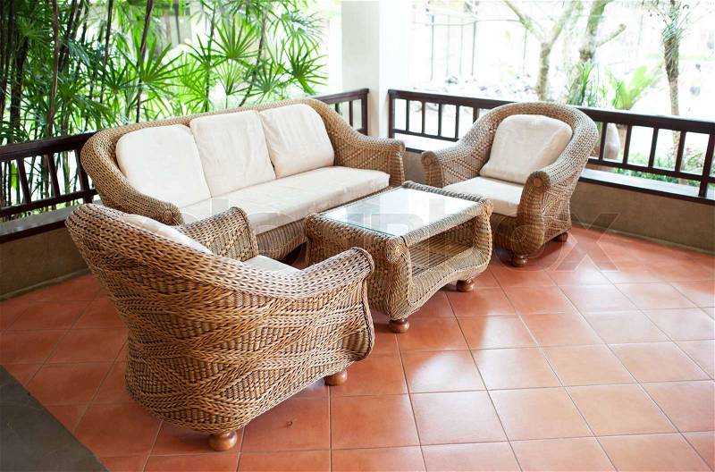 Home exterior patio with wooden decking and rattan sofa, stock photo