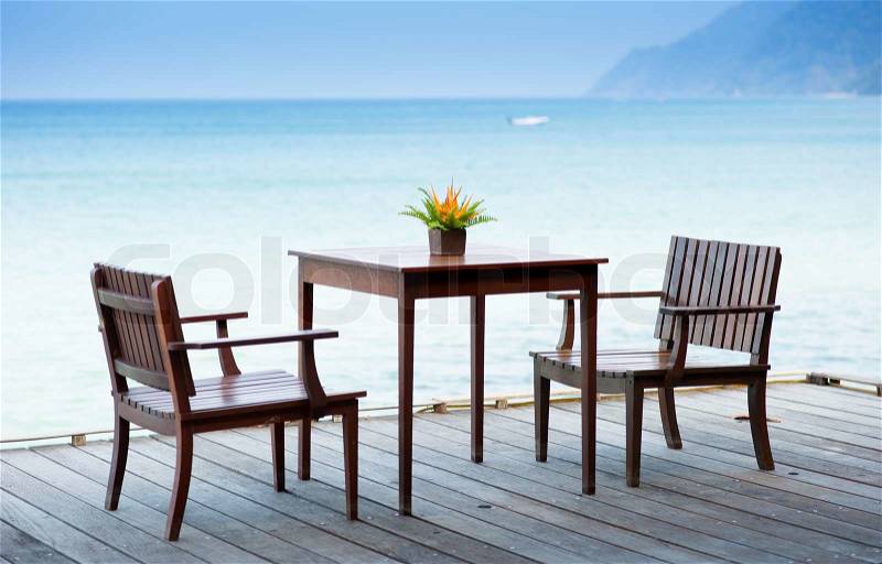Terrace sea view with outdoor wood chairs and table, stock photo