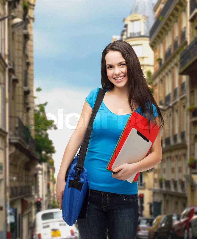 Education, technology and people concept - smiling student with bag, folders and tablet pc computer standing, stock photo