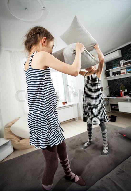 Wide angle shot of girls fighting with pillows, stock photo