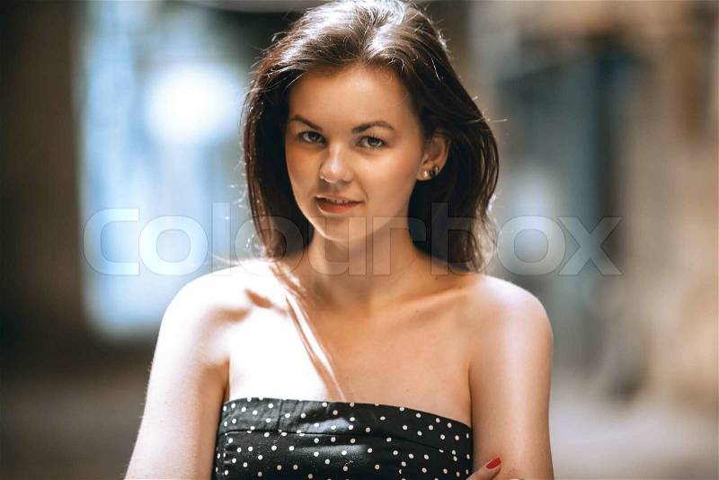 Closeup portrait of smiling brunette woman posing on street, stock photo