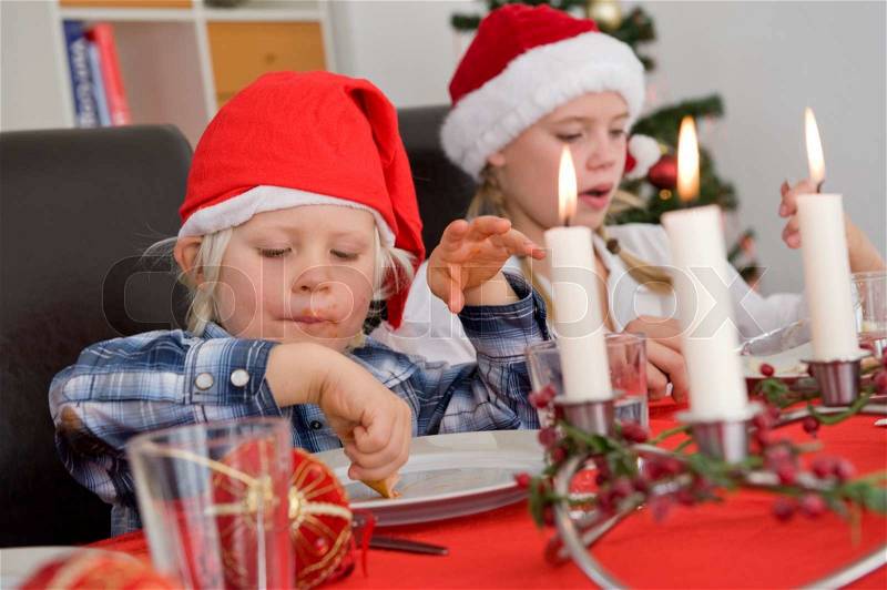 Caucasian children enjoying Christmas lunch, stock photo