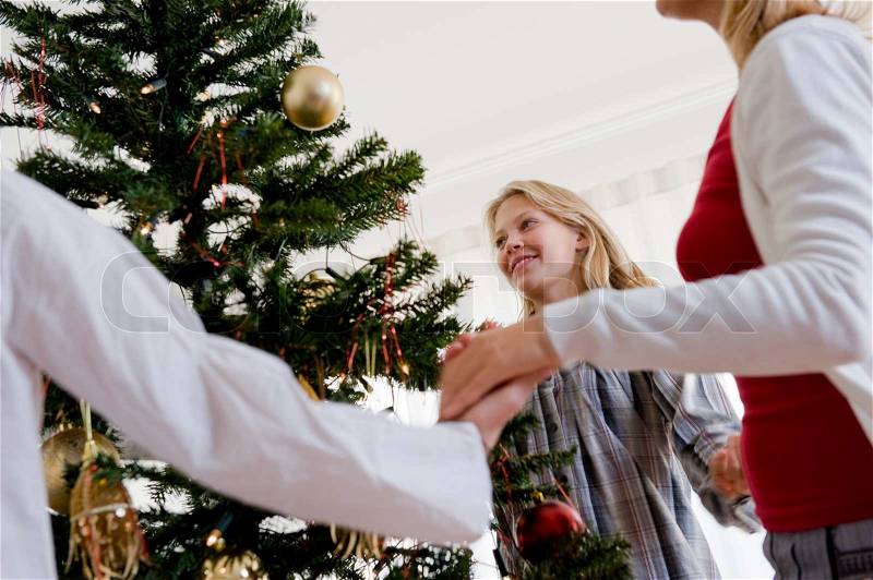 Caucasian family dancing around the Christmas tree, stock photo