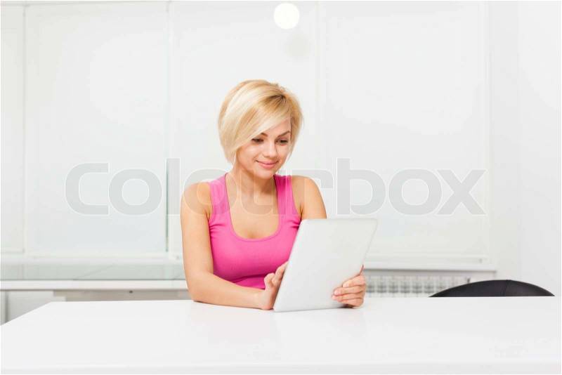 Beautiful woman with tablet touch screen pad sitting table home, pretty girl surfing on digital computer, modern bright room, stock photo