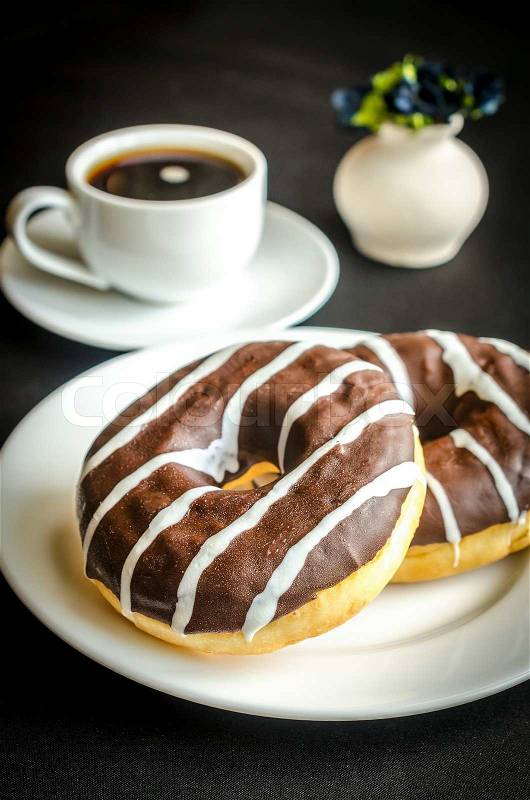 Chocolate donuts with a cup of coffee, stock photo