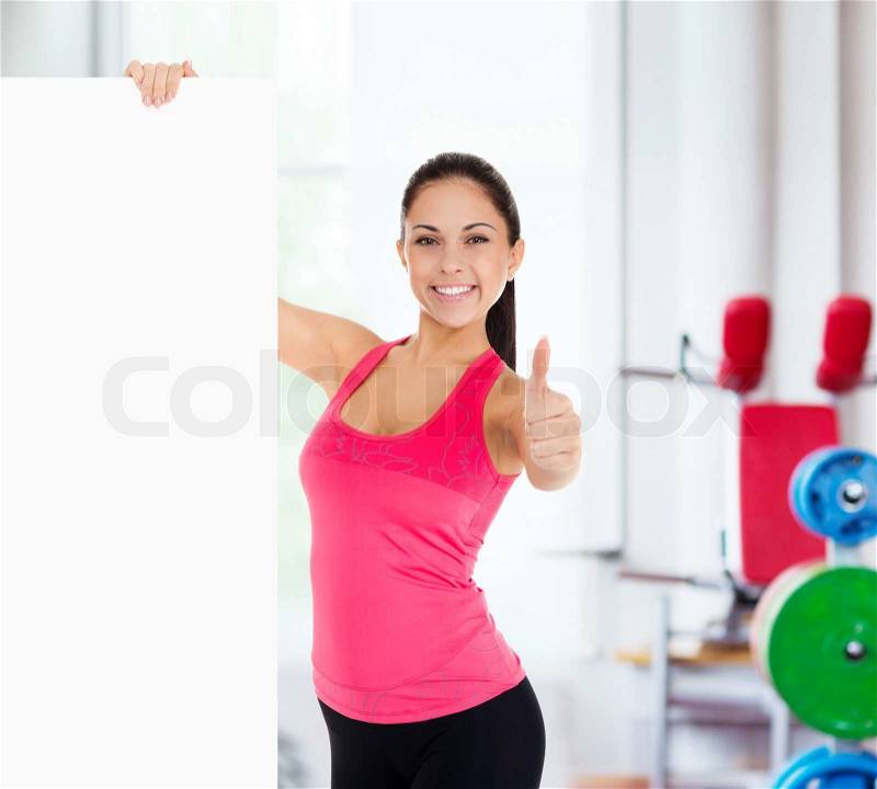 Sport fitness woman hold blank board advertisement with empty copy space, young healthy smile girl athletic muscle body, perfect figure show thumb up gesture, stock photo