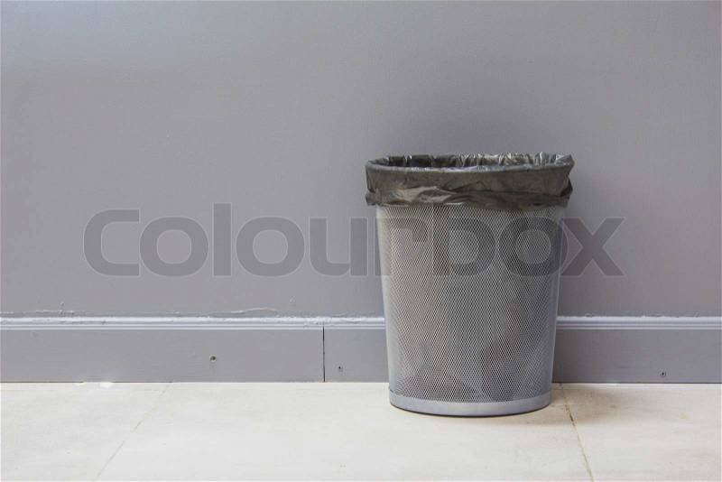 An empty metal trashcan (bin) isolated on gray background, stock photo