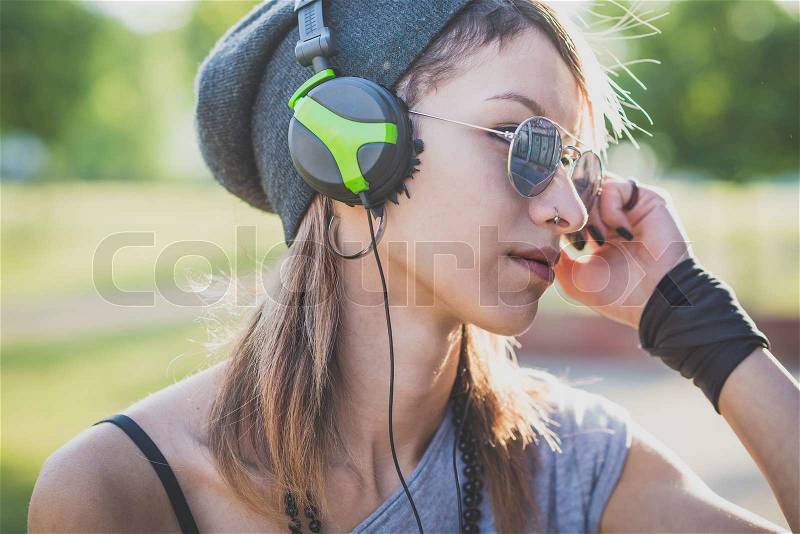 Young beautiful model woman listening music in the city, stock photo