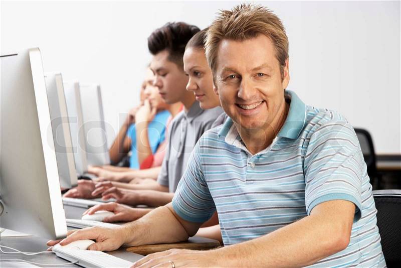 Portrait Of Tutor With Students In Computer Class, stock photo