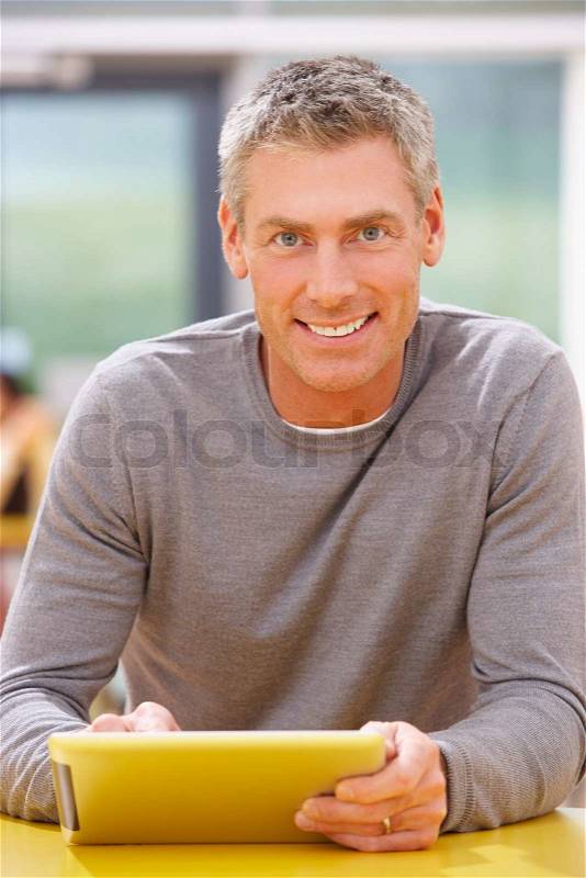 Mature Student Studying In Classroom With Digital Tablet, stock photo