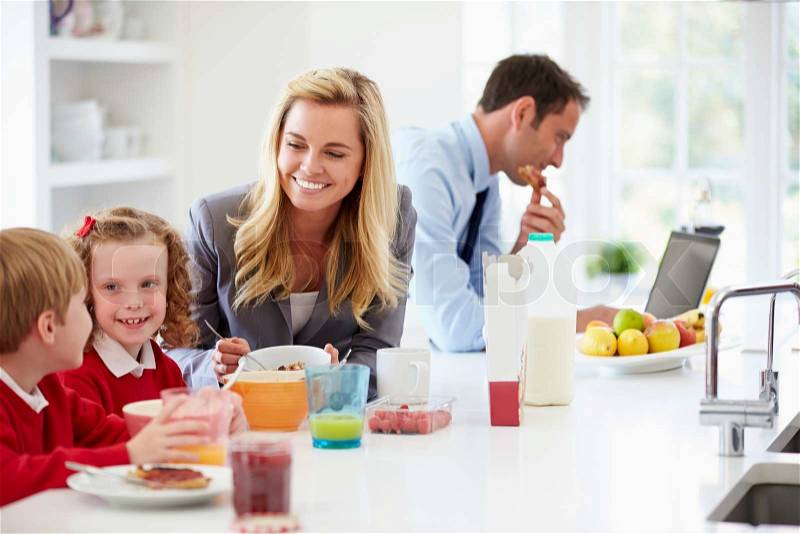 Family Having Breakfast In Kitchen Before School And Work, stock photo