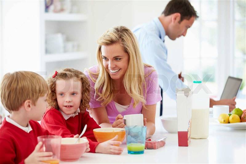 Family Having Breakfast In Kitchen Before School And Work, stock photo