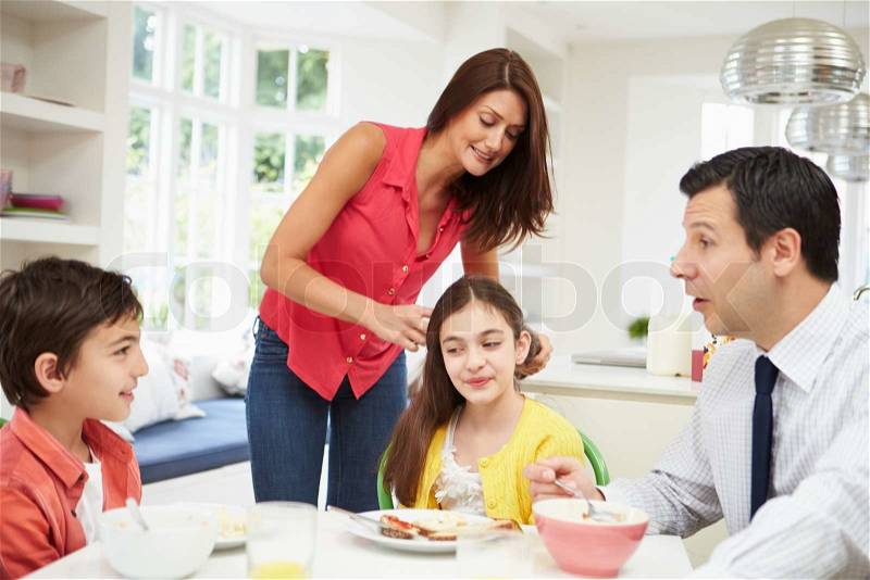 Family Having Breakfast Before Husband Goes To Work, stock photo
