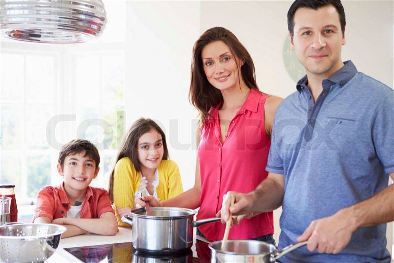Hispanic Family Cooking Meal At Home Together, stock photo